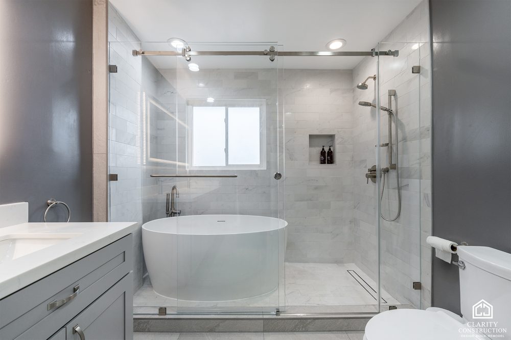 Primary bathroom with a freestanding tub, marble shower and a wall of glass