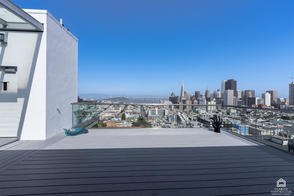 Rooftop deck with composite boards and a glass railing over the San Francisco skyline