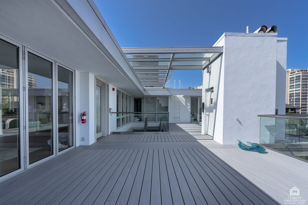 Rooftop terrace running the length of a penthouse, in gray composite decking