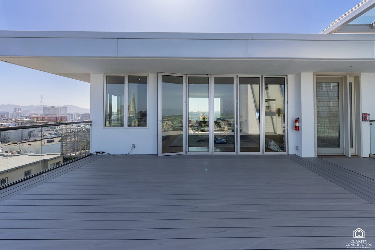 Rooftop deck outside the penthouse sliding doors with the city behind
