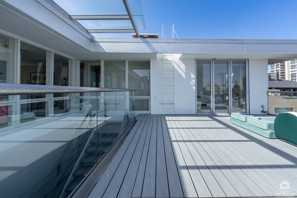 Rooftop deck with a spa, glass railing and city views on three sides