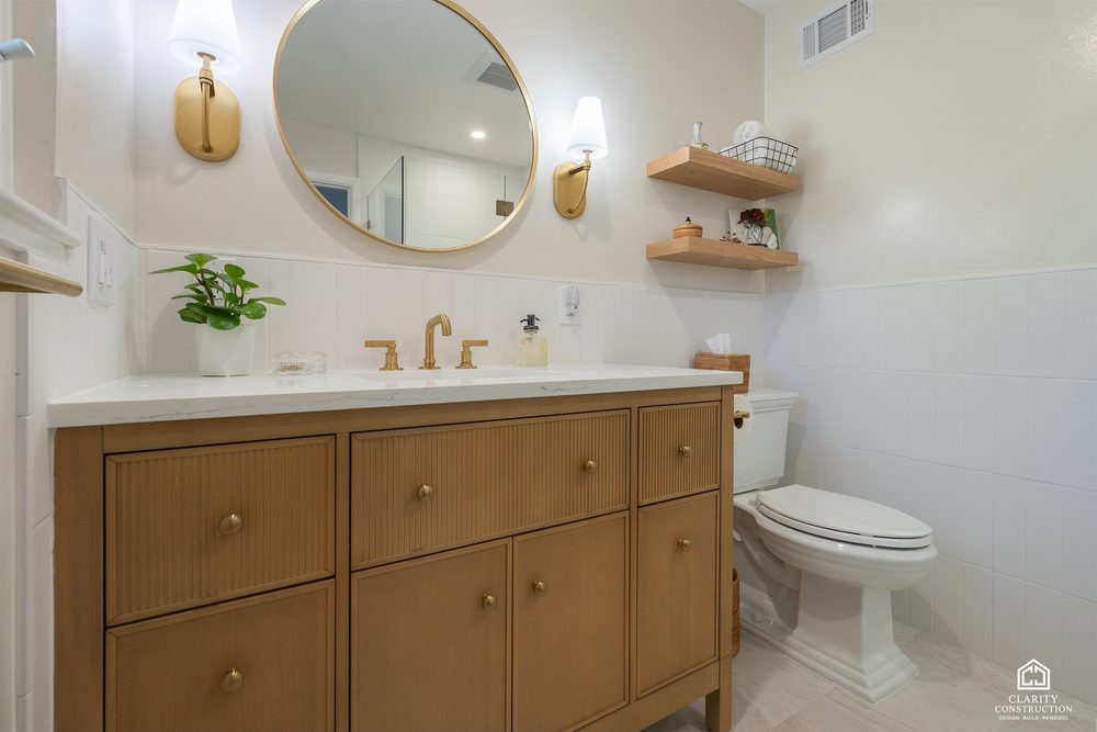 Fluted oak vanity with a round mirror, brass faucet and floating shelves