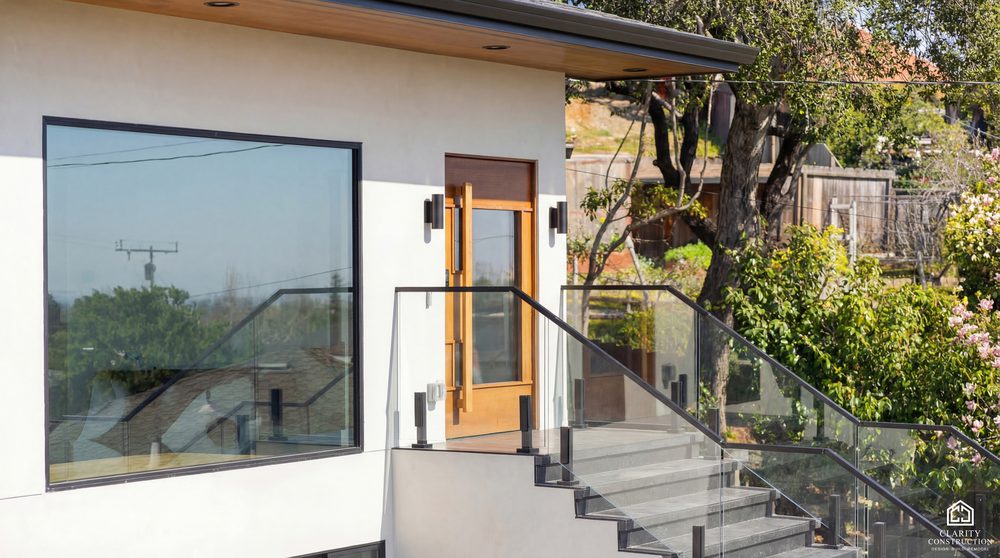 Glazed entry with a stained wood front door and a glass balustrade stair