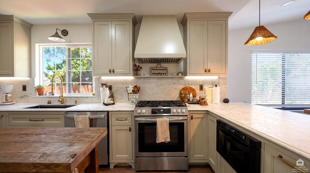 Range wall with a plastered hood, marble backsplash and sage shaker cabinetry