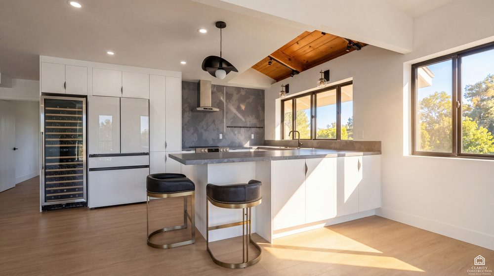 White kitchen with a cedar ceiling, black framed windows and an island with bar seating