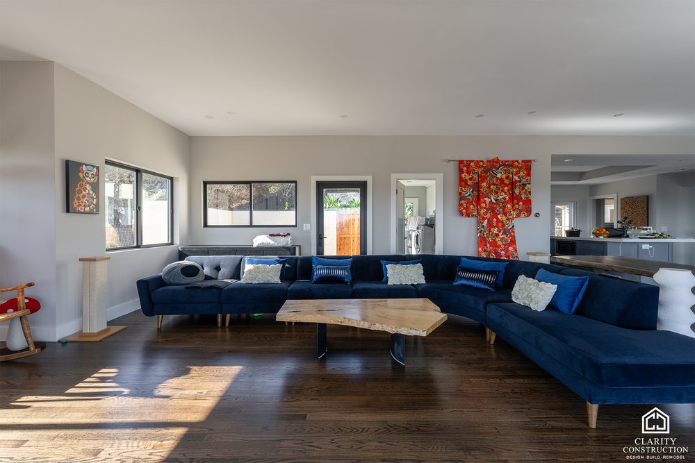 Living room with a large sectional sofa, dark wood floors and sliding glass doors to the deck