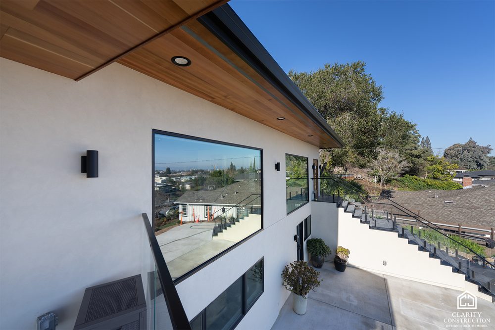 Rear of the house seen from the deck, with a cedar soffit and black window frames