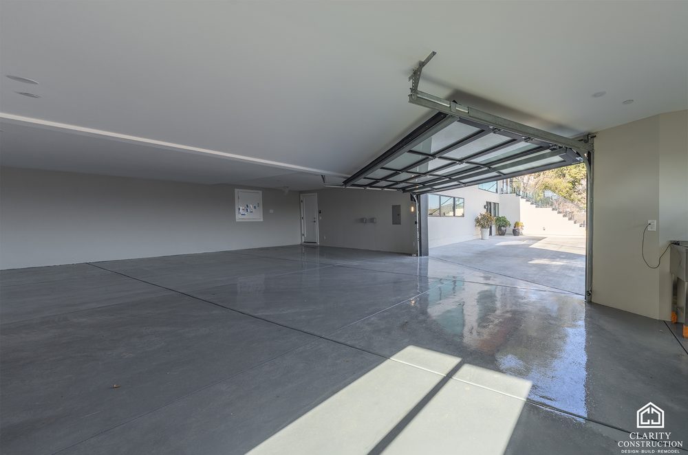 Garage with a gray epoxy floor and the full-width door open to the driveway