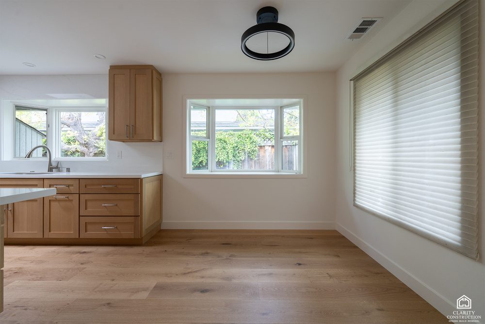 Corner of the kitchen with windows on two sides and wood cabinets