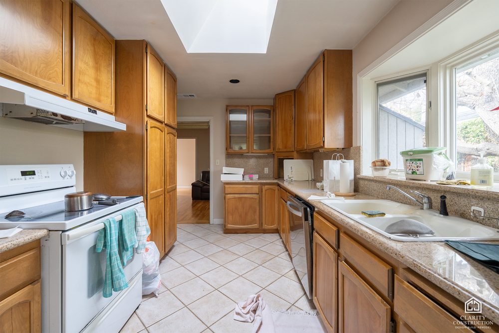The original closed-off kitchen with dark wood cabinets and tile floors