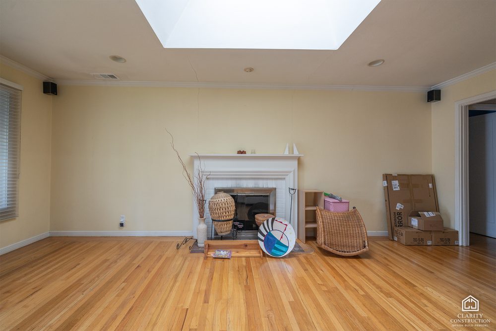 The original living room with a small fireplace before demolition