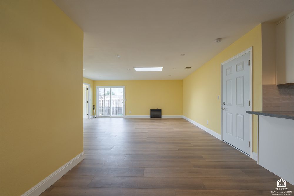 Open living and dining floor with new wood floors and French doors to the yard