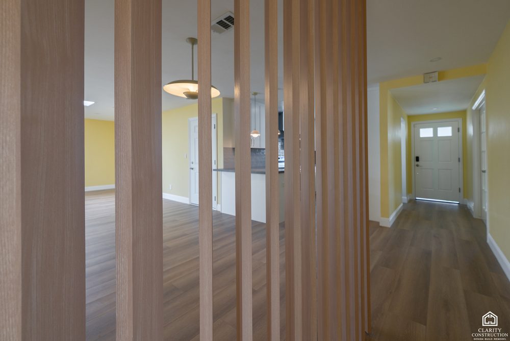 Entry hall with a slatted wood screen and new wood floors