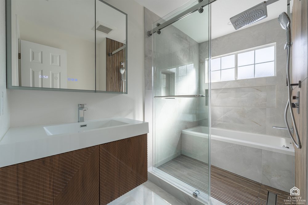 Deep soaking tub under a window with a slatted wood wall