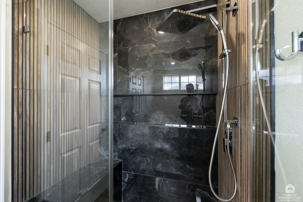 Second bathroom with a black large-format tile shower and a rain head