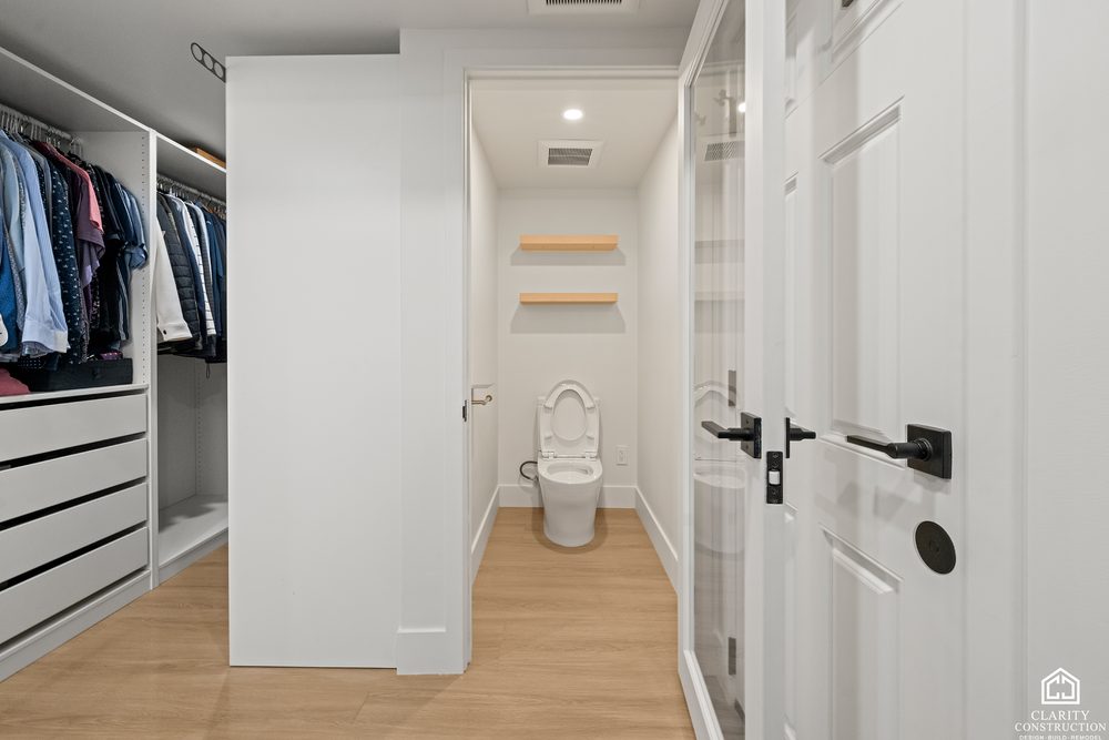Walk-in closet with white shelving and hanging space