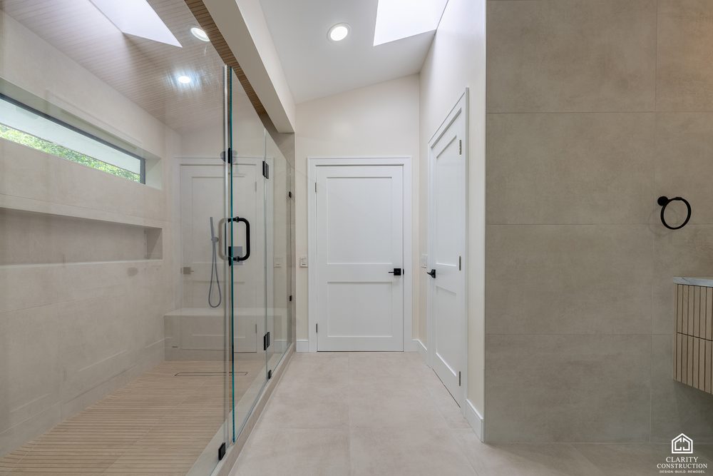 Curbless shower with large-format tile, a skylight and a glass door
