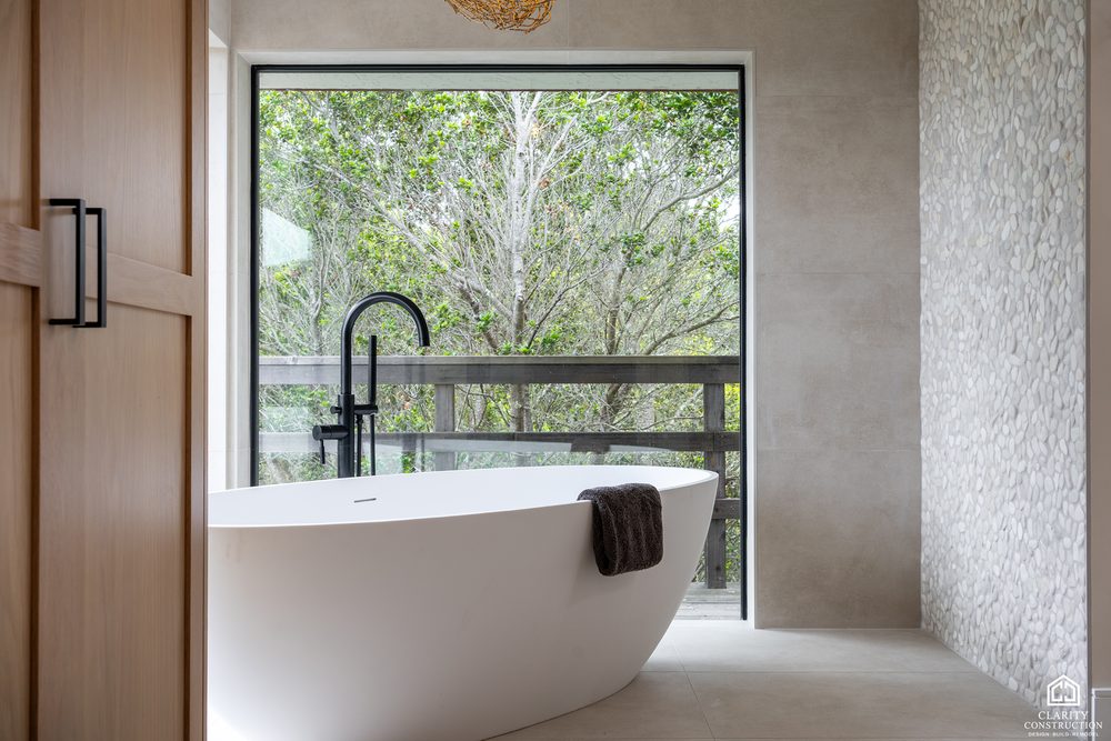 Freestanding tub seen from the wardrobe wall with the window behind