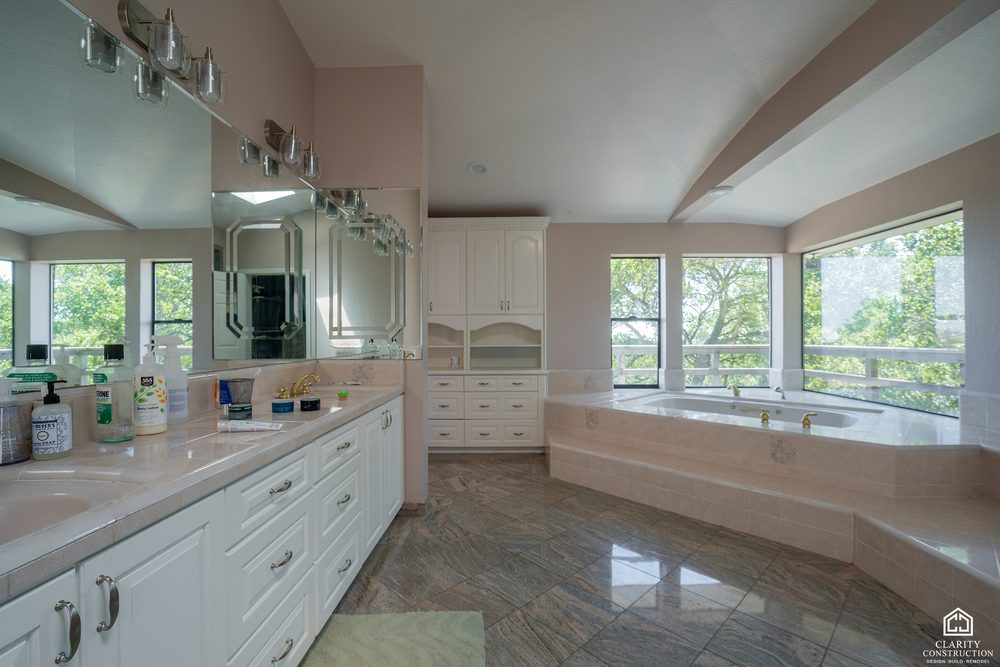 The original long white vanity and step-up jetted tub