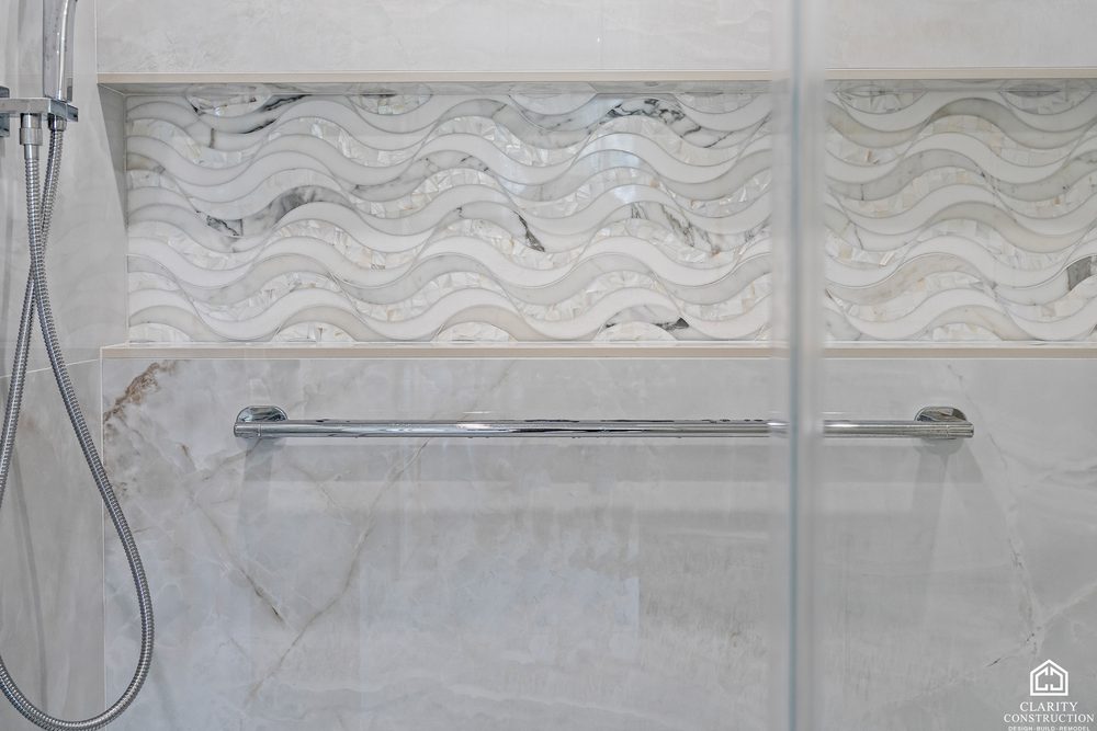 Wave-patterned stone niche set into the shower wall