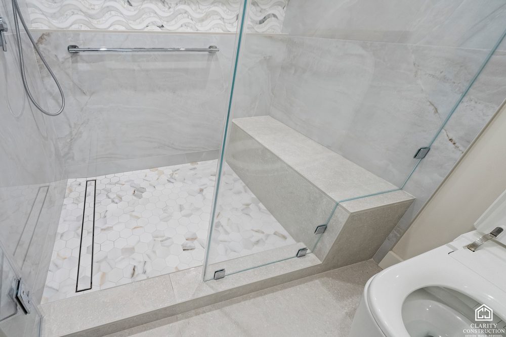 Shower bench and linear drain behind frameless glass