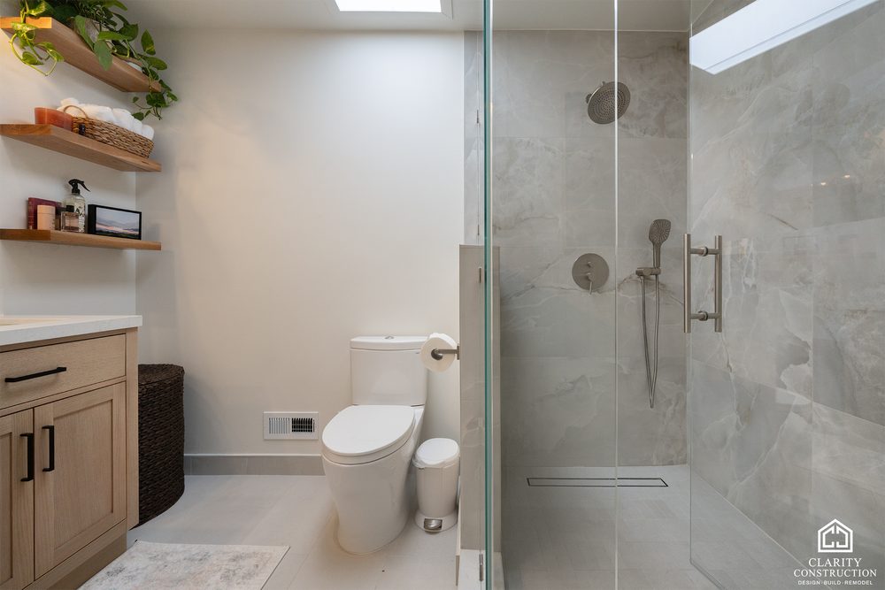 Bathroom with a floating shelf, a plant ledge and the glass shower beyond