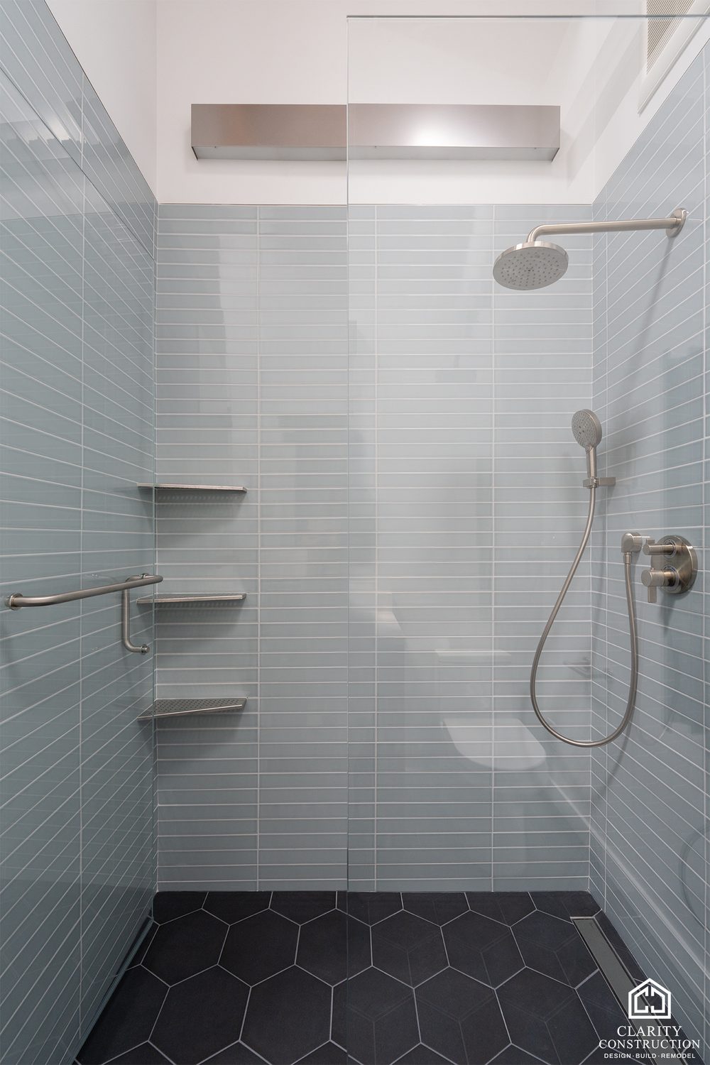Glass-tile shower with a corner shelf and a rain head