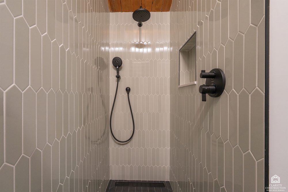Picket-tile shower with black fixtures and a tiled niche