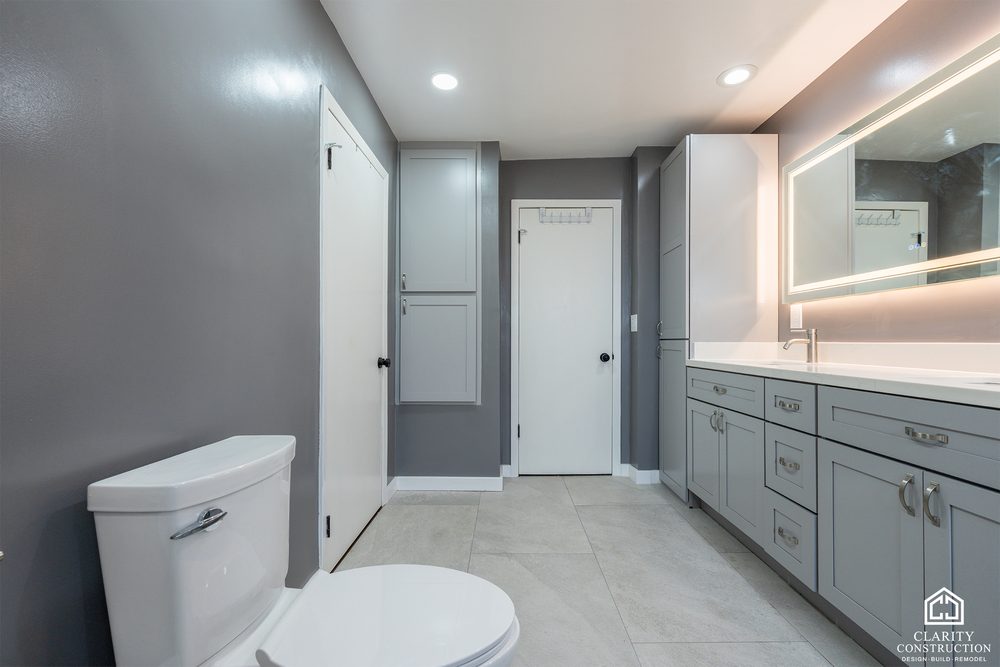Primary bathroom seen from the door with charcoal walls and a gray vanity