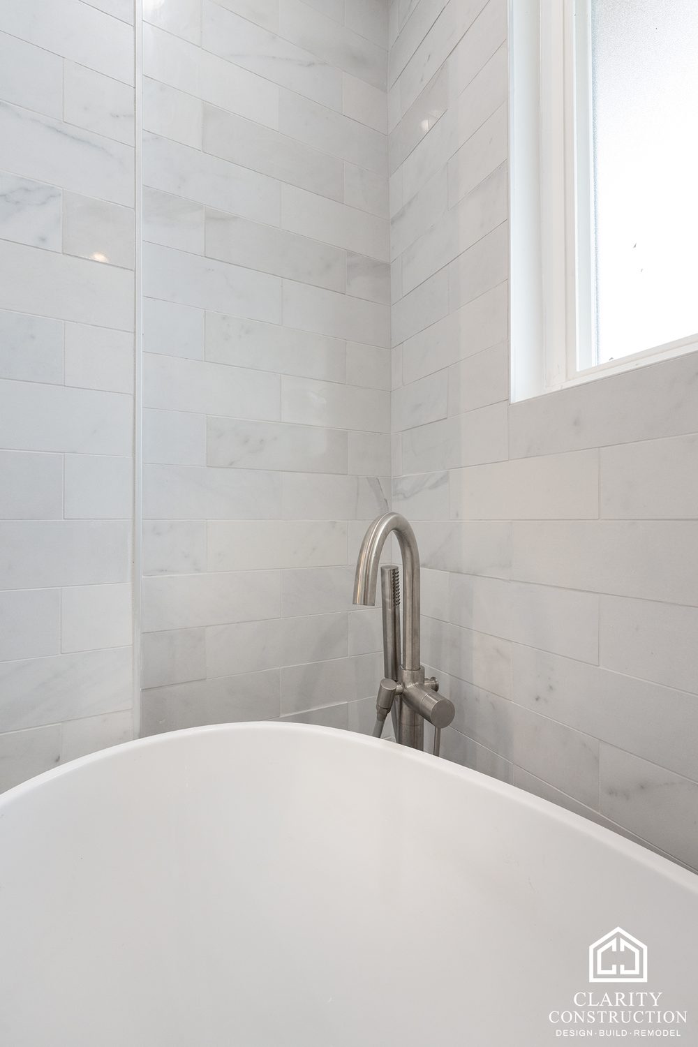 Floor-mounted tub filler beside the freestanding tub