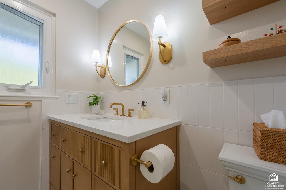 Oak vanity with a white counter, brass faucet and floating oak shelves