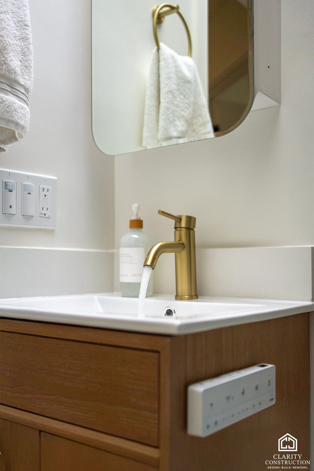 Oak vanity with a brass faucet and a white sink