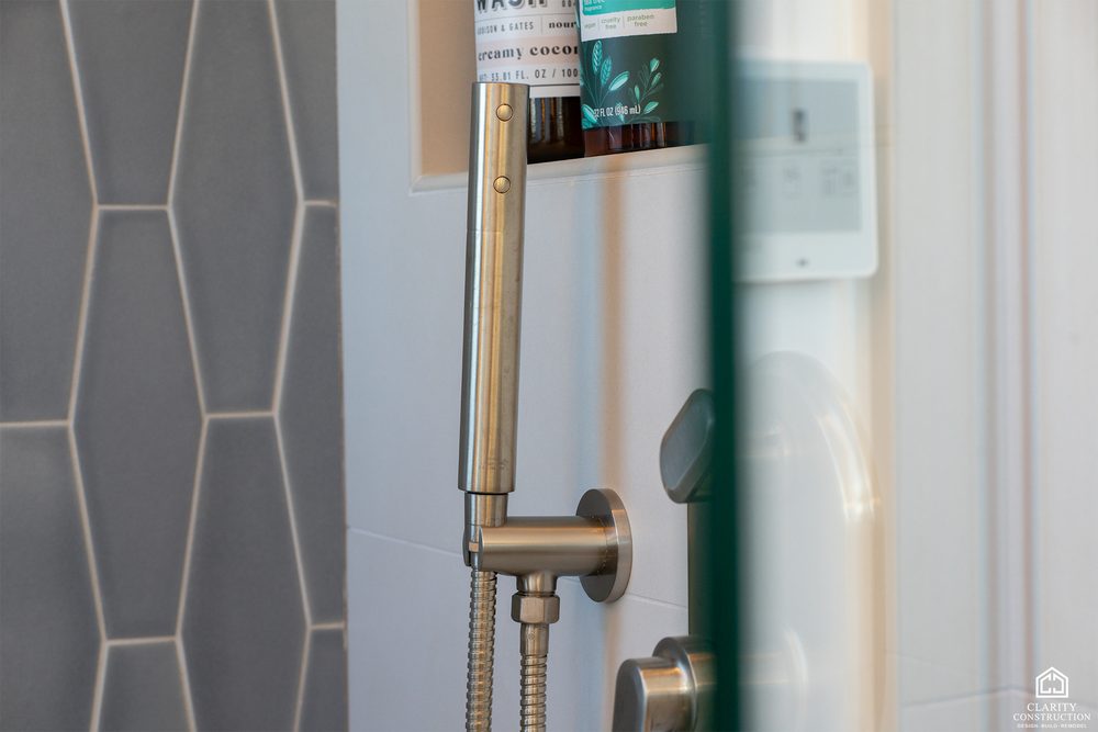 Gray hex tile and a brushed nickel hand shower in the attic bathroom