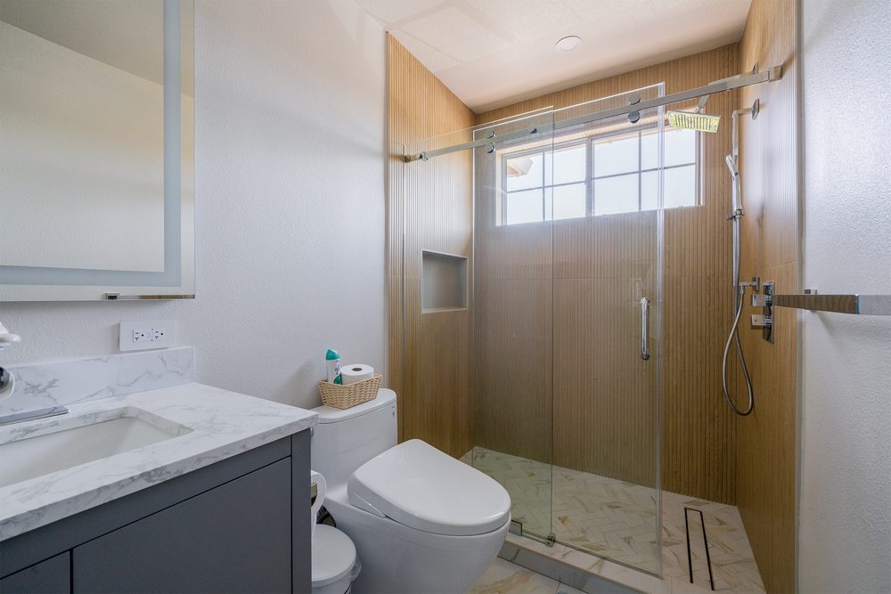 Gray vanity and sliding glass shower door in the second bathroom
