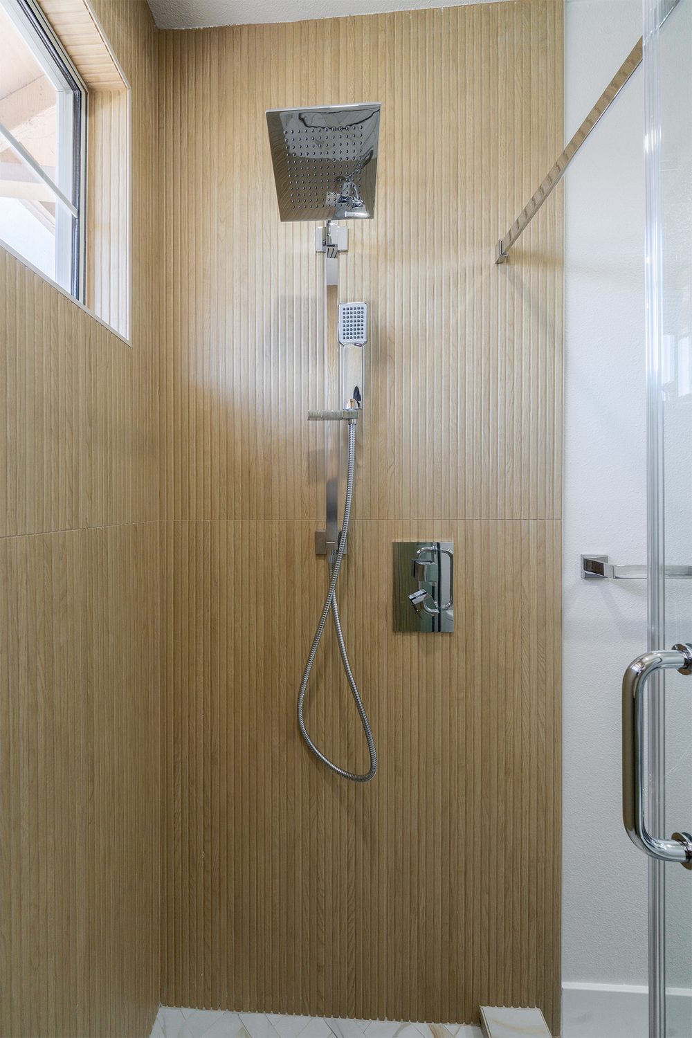 Wood-look tile shower with a rain head and a linear drain