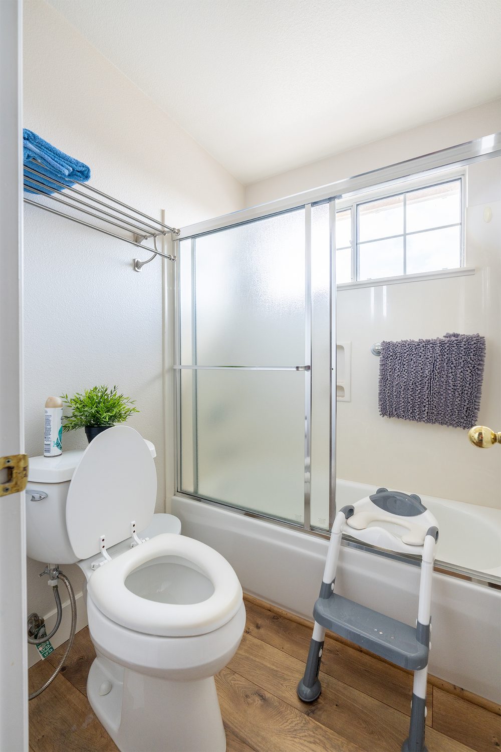 The original hall bathroom with a sliding glass tub door