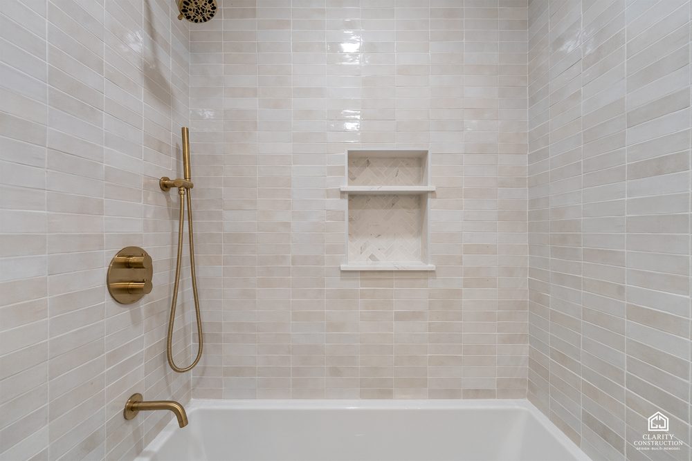 Brass rain head and hand shower over the tub in the guest bath