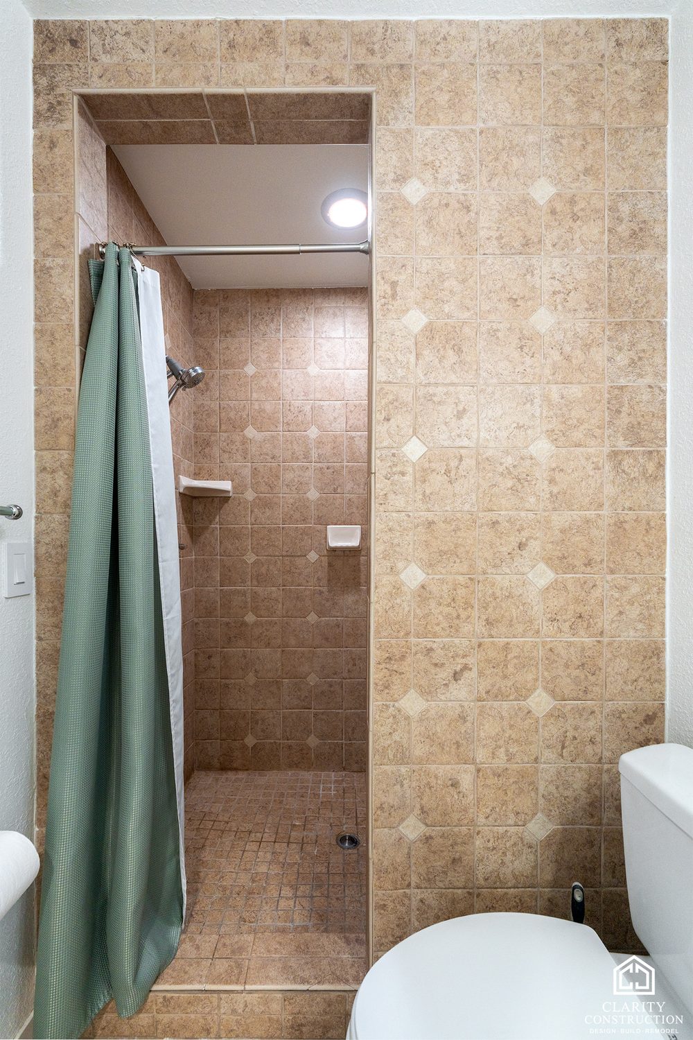 The original beige tile shower with a curtain