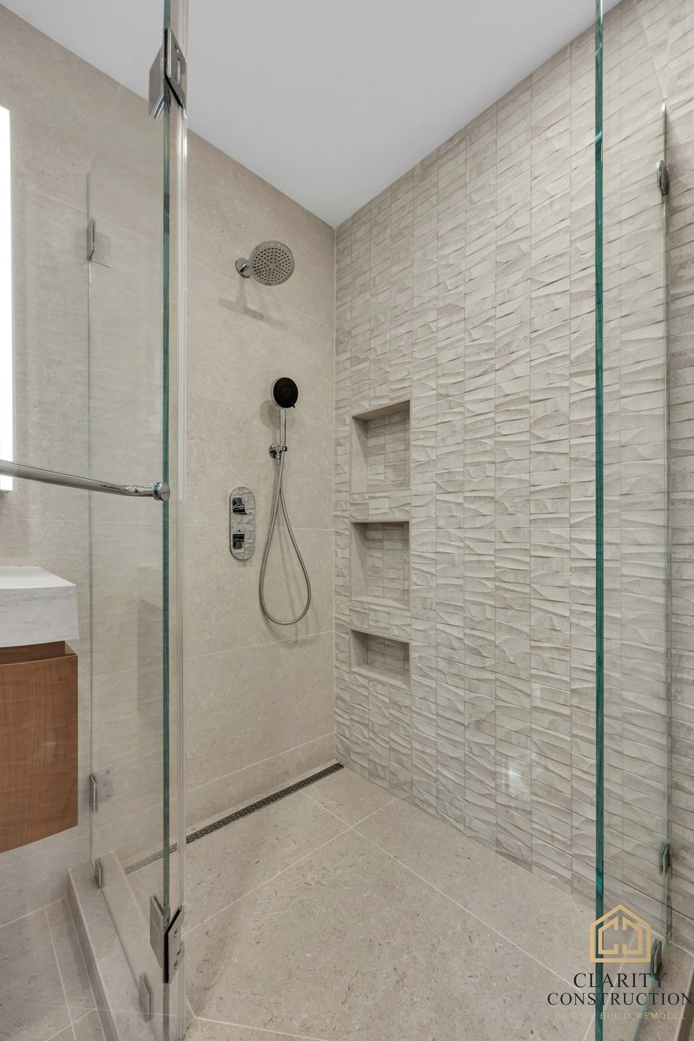 Curbless shower floor with a linear drain and large-format porcelain walls