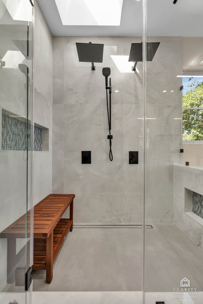 Shower with a teak bench and a mosaic tile niche