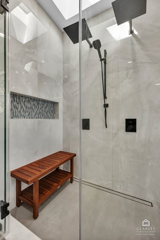 Mosaic niche and teak bench inside the shower
