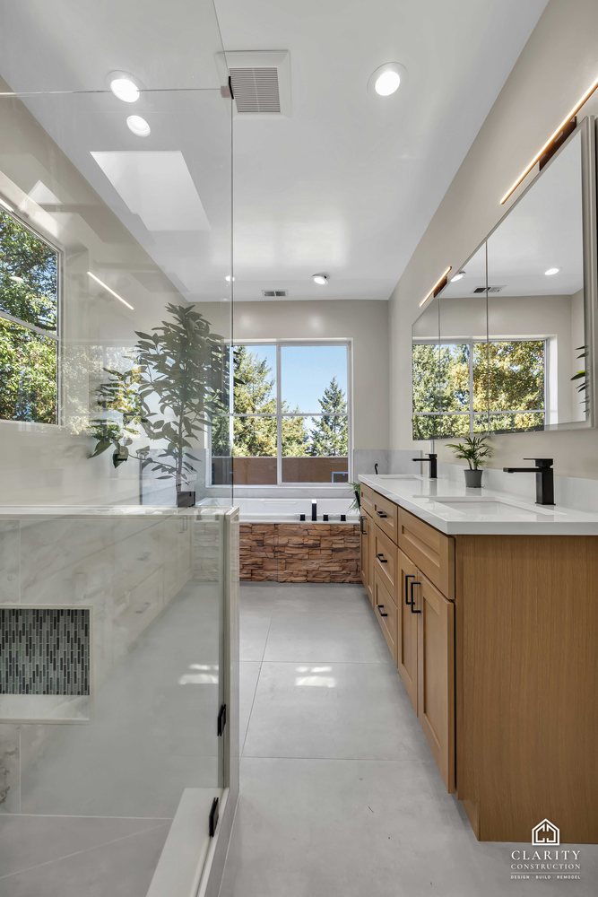 White oak vanity beside the shower, window to the trees