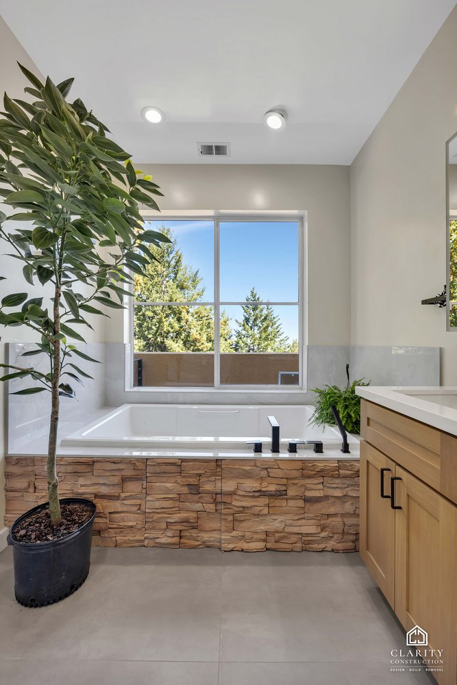 Soaking tub under the window with a stacked-stone surround