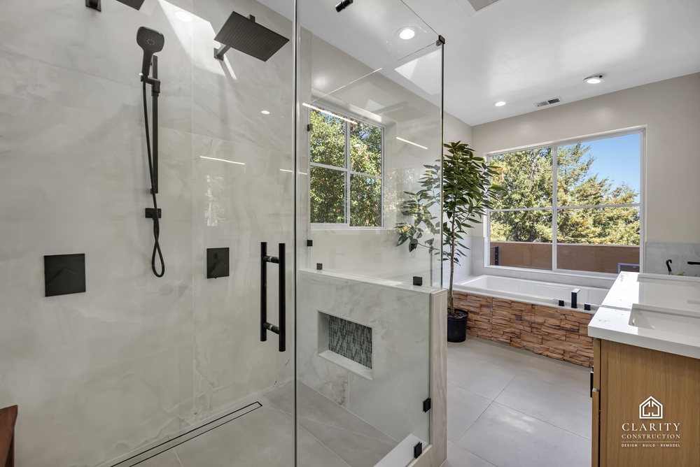 Shower with black fixtures looking toward the tub