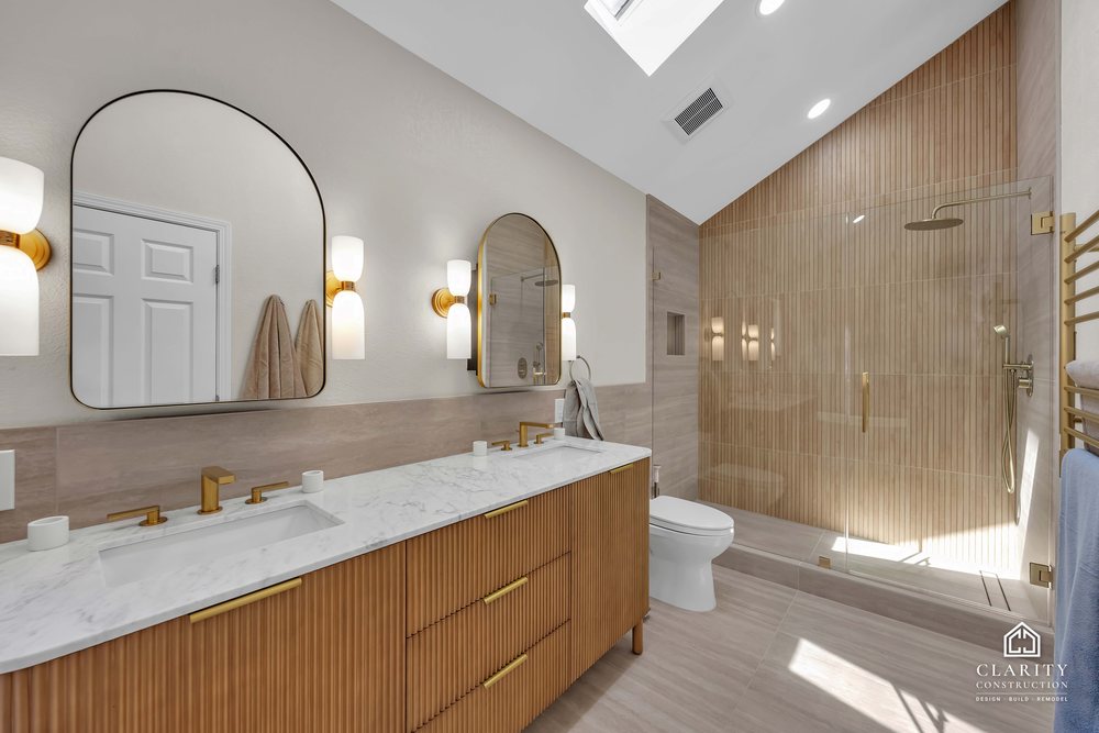 Primary bath: vanity, towel rail and shower under the vaulted ceiling