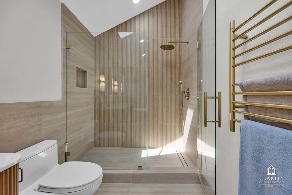 Primary bath: walk-in shower with a built-in niche and brass towel rail