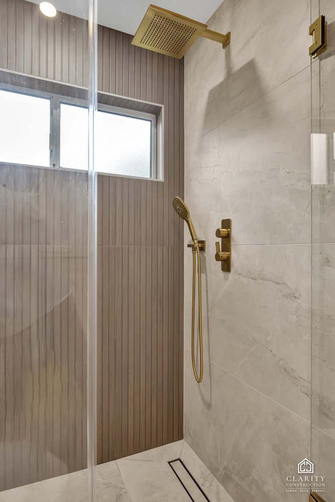 Hall bath: fluted tile shower wall with brass fixtures