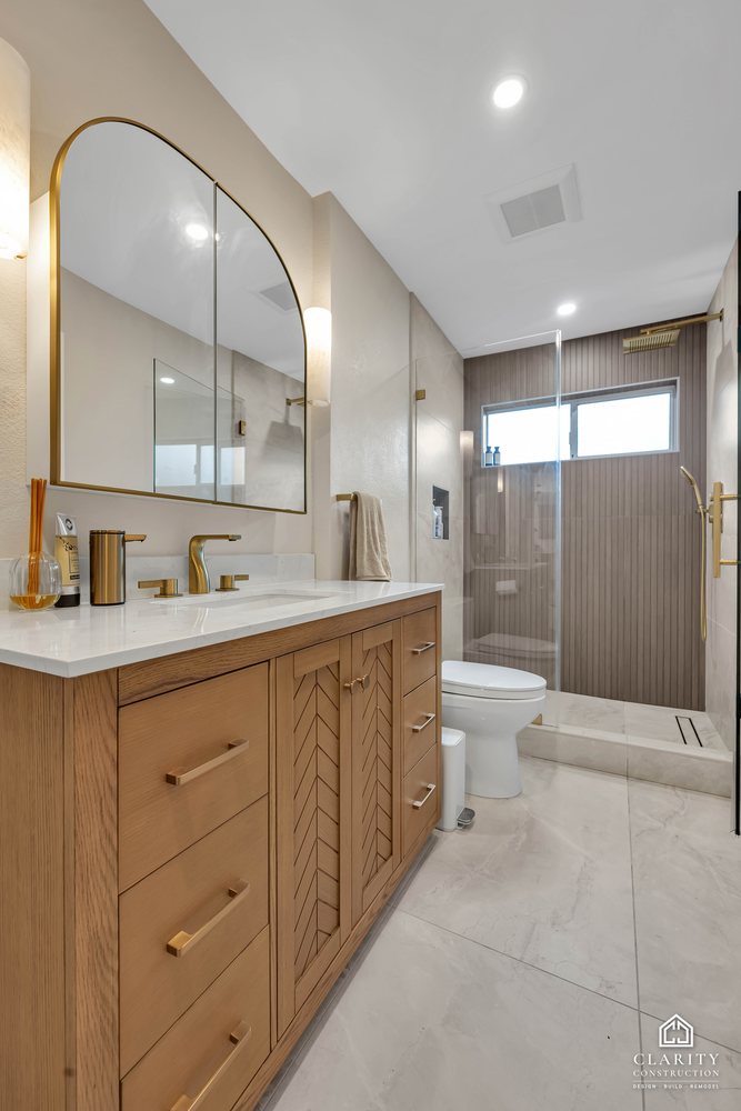 Hall bath: arched mirror and brass sconce over the vanity