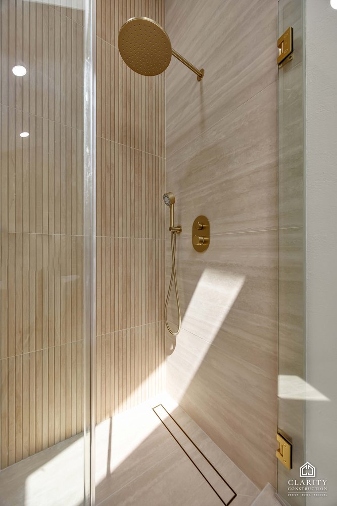 Hall bath: brass rain head and hand shower inside the glass shower