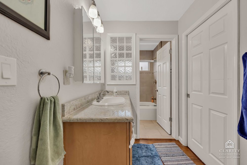 Before: the hall bath with its oak vanity, built-in tub and sliding shower door